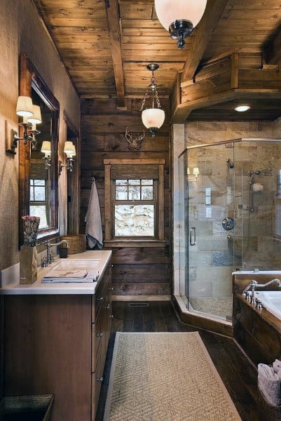 Rustic bathroom with wood-paneled ceiling, glass shower, and wooden vanity.