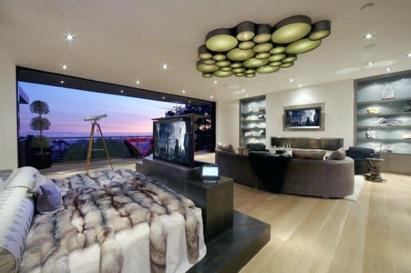 Modern bedroom with ocean view, unique ceiling lights, and fur bedding.