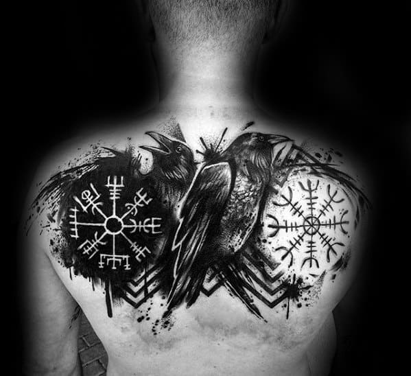 Back tattoo featuring two ravens and two Nordic symbols with abstract black ink splashes