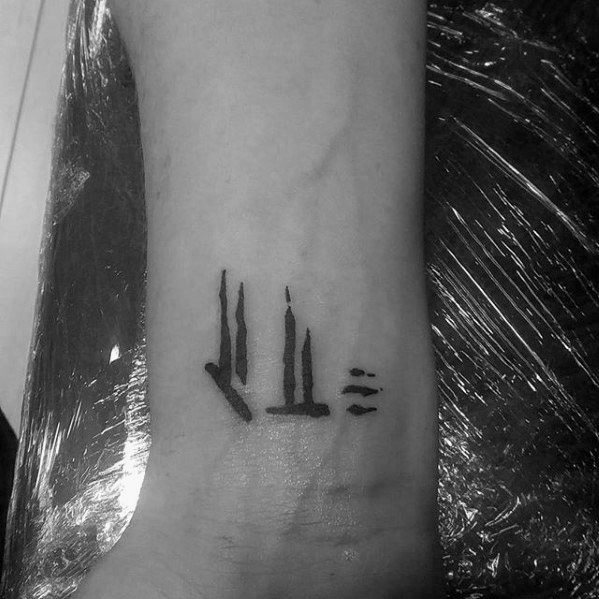 Tattoo of abstract vertical lines, reminiscent of Skyrim, on a person's wrist
