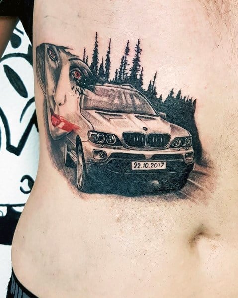 Detailed BMW X5 tattoo on ribs, featuring a forest backdrop and a woman's face for a unique and artistic automotive design.