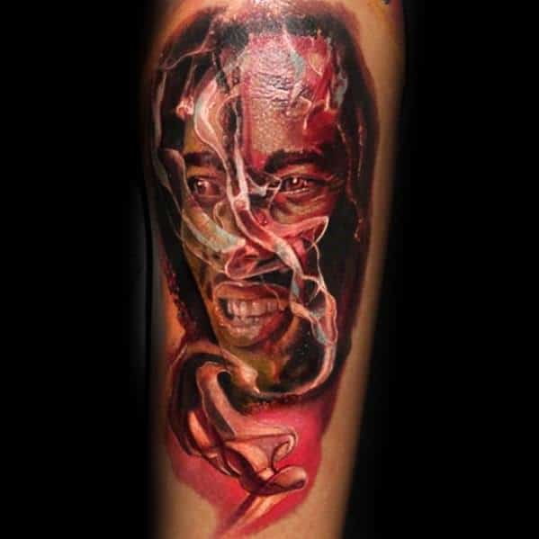 Vivid color tattoo of Bob Marley with swirling smoke across his face and hand, blending realism with abstract elements in red and warm tones.