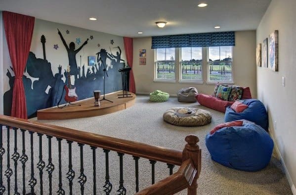 Fun playroom with a small stage, colorful bean bags, and a vibrant mural wall.