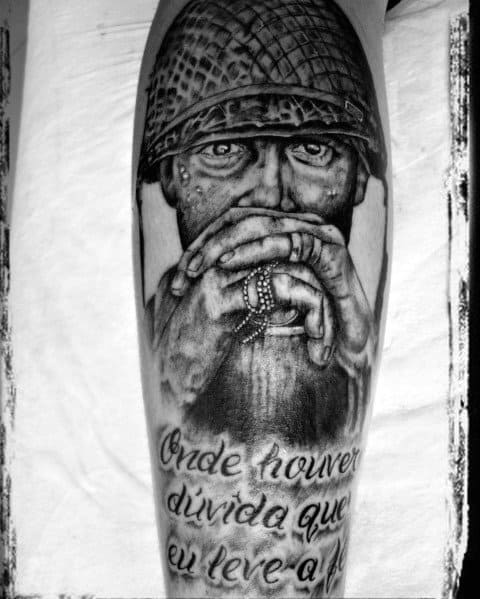 Realistic Call of Duty soldier tattoo with a detailed helmet and intense gaze, featuring a thoughtful pose and script text on the lower leg.
