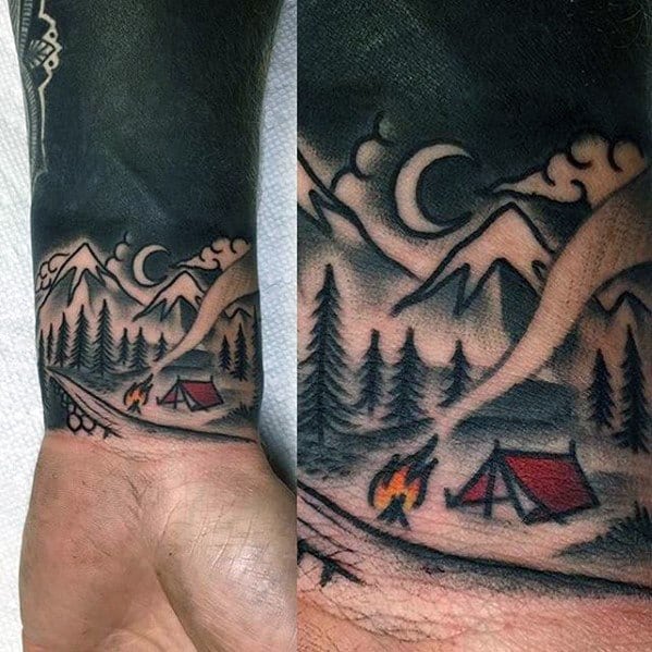 Traditional-style campfire tattoo with a tent, pine trees, mountains, and crescent moon under a smoky night sky.