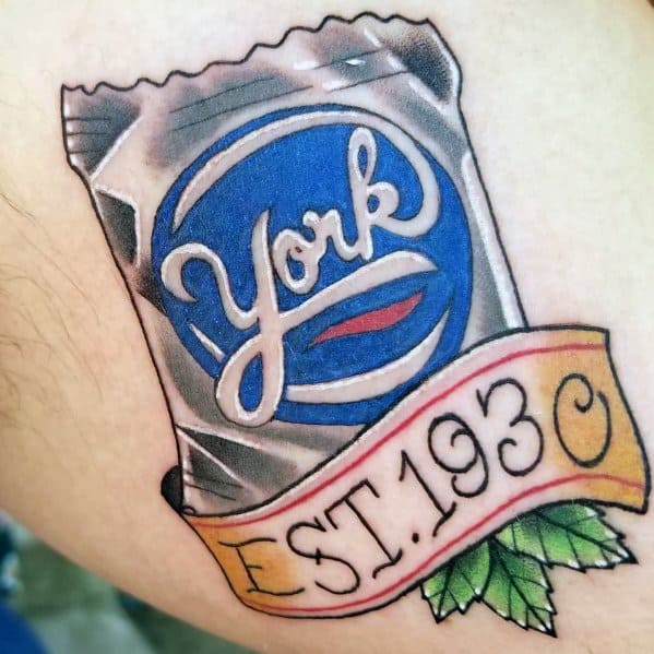 Tattoo of a York Peppermint Pattie wrapper with a vintage-style banner reading "EST. 1930," accented with green mint leaves.