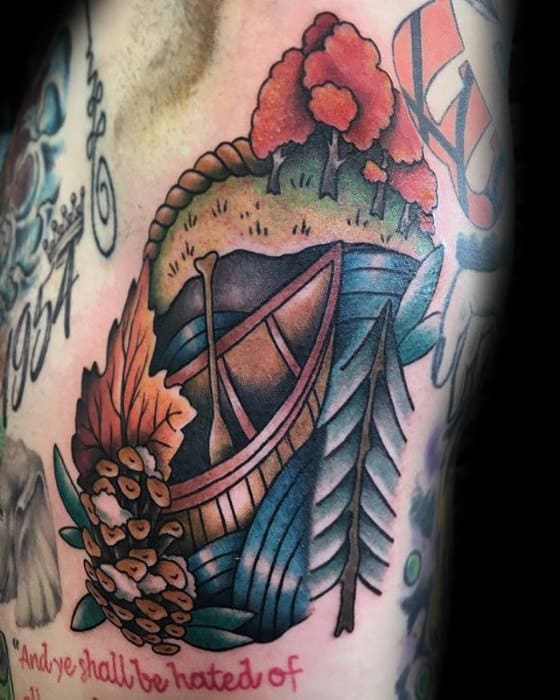 Alt text: Colorful tattoo of a canoe surrounded by foliage, trees, and flowers, capturing a vibrant natural scene.