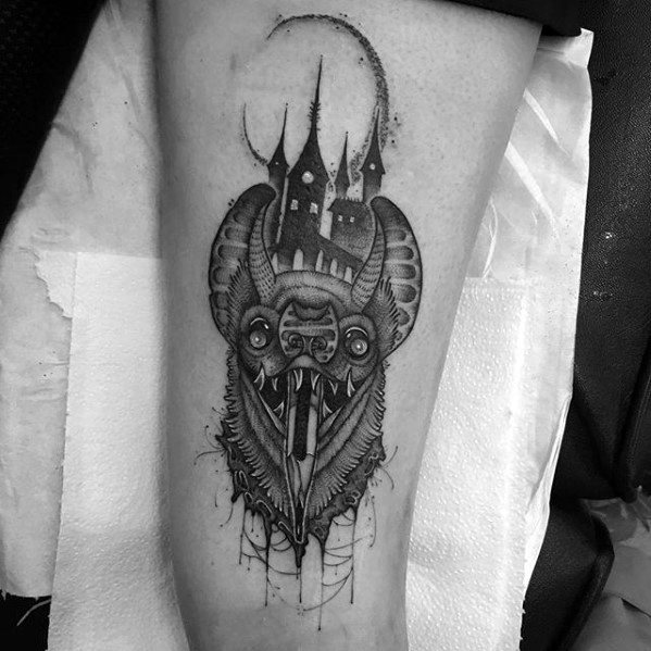 A pencil sketch-style tattoo of a bat, featuring a gothic castle, adorns a person's arm in striking black and white