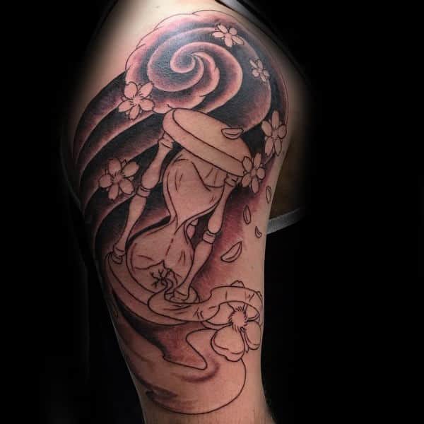Upper arm tattoo featuring an hourglass with flowing sand, surrounded by swirling wind patterns and delicate cherry blossoms