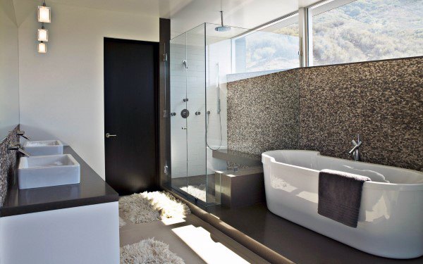 Modern bathroom with bathtub, shower, twin sinks, and mountain view