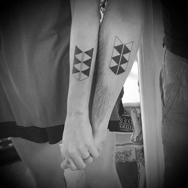 Minimalist geometric couple tattoos on forearms, forming a complete symmetrical pattern when placed side by side.