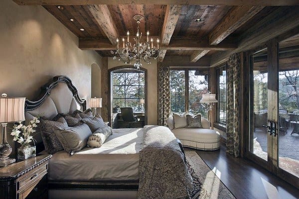 Elegant Victorian-inspired bedroom with wood beam ceiling and chandelier.