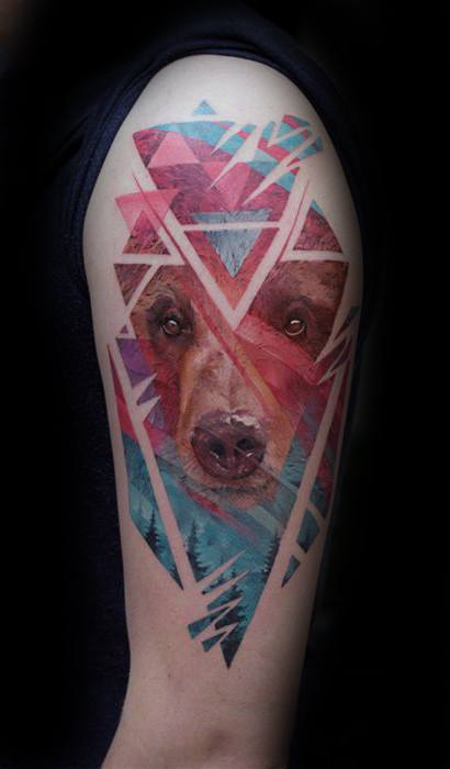Geometric bear tattoo with a realistic bear face blended into colorful abstract shapes and forest elements on the upper arm.