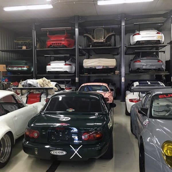 A gentleman’s garage packed with sports cars and multi-level storage racks for optimized space.