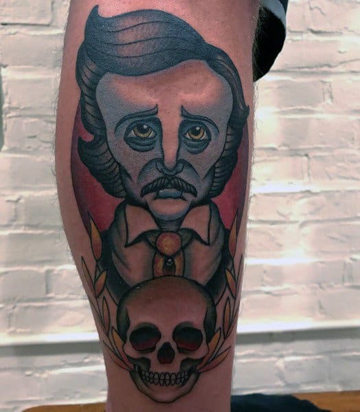 Color tattoo of Edgar Allan Poe with a solemn expression, wearing a suit and tie, featuring a skull and laurel leaves below his portrait.