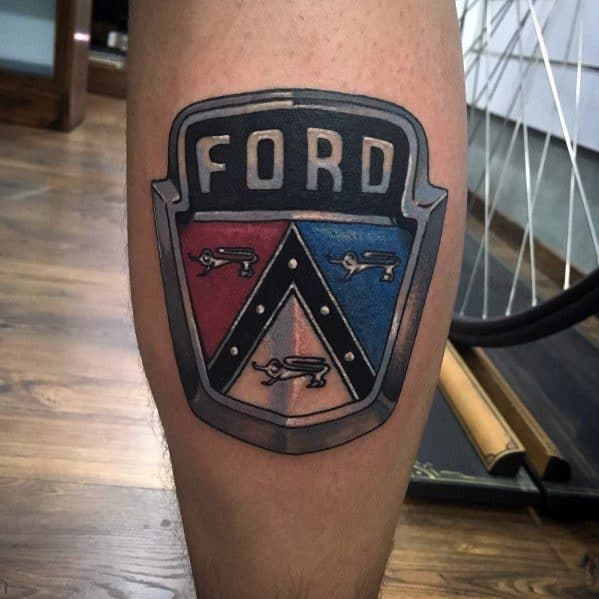 Ford emblem tattoo on calf featuring a bold black, red, and blue shield design with classic detailing and a metallic effect.