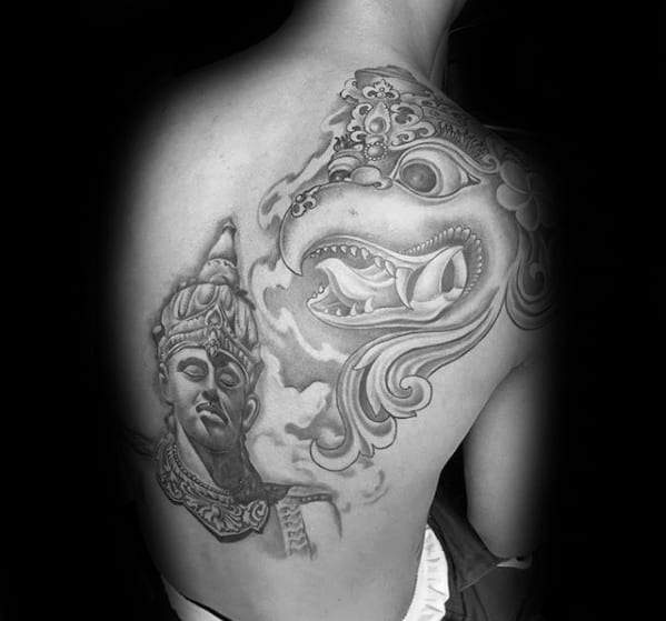 Garuda tattoo on the back featuring a serene deity face and a fierce mythological bird, with soft shading and flowing ornamental lines.