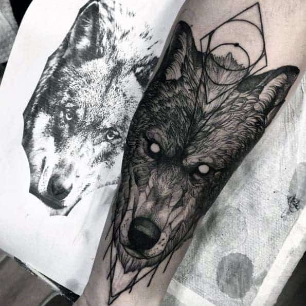 Forearm tattoo of a wolf with geometric elements