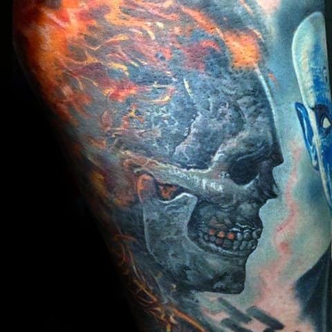 Realistic Ghost Rider tattoo with a charred skull, fiery flames, and glowing orange eyes, blending dark tones and vibrant fire.