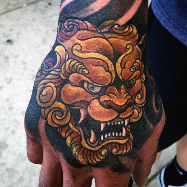 Awesome Gold Foo Dog Hand Tattoo On Male