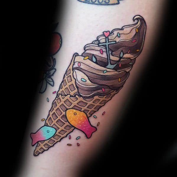 Whimsical tattoo of a chocolate soft-serve ice cream cone with sprinkles, a heart-tipped stick, and two colorful fish-shaped candies.