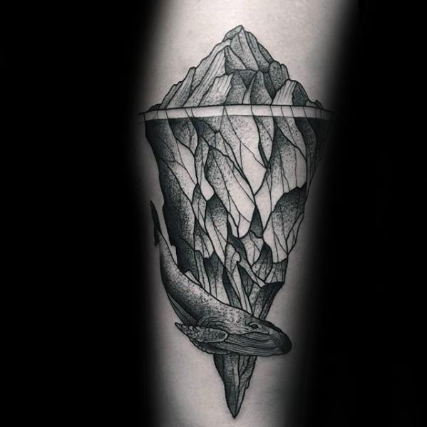 Realistic iceberg tattoo with sharp shading and a whale swimming beneath the surface, highlighting depth and ocean mystery.