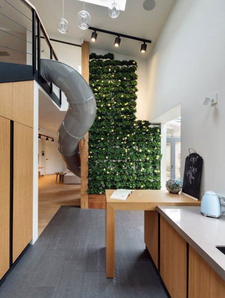 Modern interior featuring a green wall, slide to the lower level, and elegant wooden and white surfaces