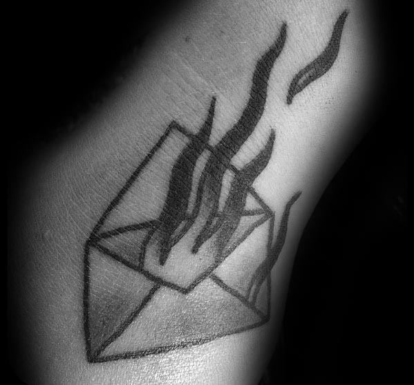 Tattoo of an envelope in flames, elegantly inked in black and gray