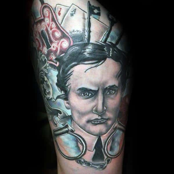 Realistic tattoo of Harry Houdini with playing cards, chains, and handcuffs, symbolizing escapism