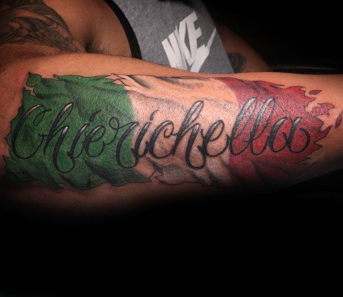Italian flag tattoo on the forearm with a torn skin effect and the word "Chierichella" in elegant script across the design.