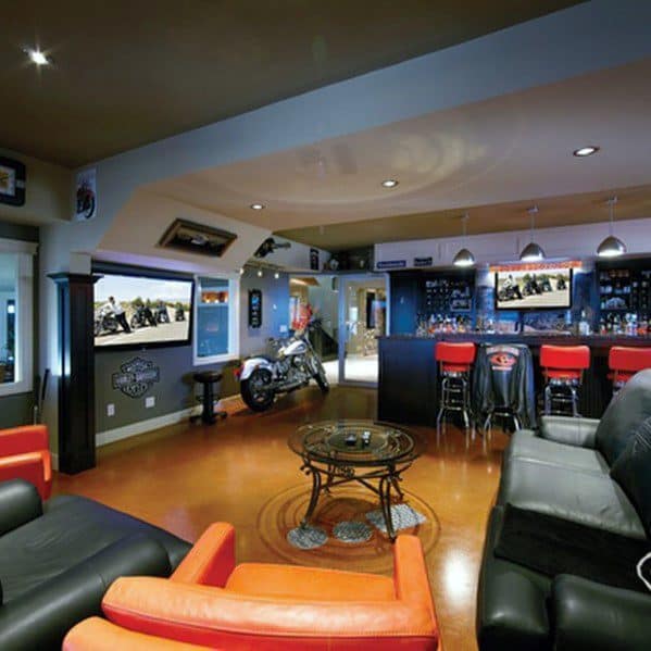 Stylish home bar with motorcycle decor, leather couches, and a TV screen displaying a motorcycle scene