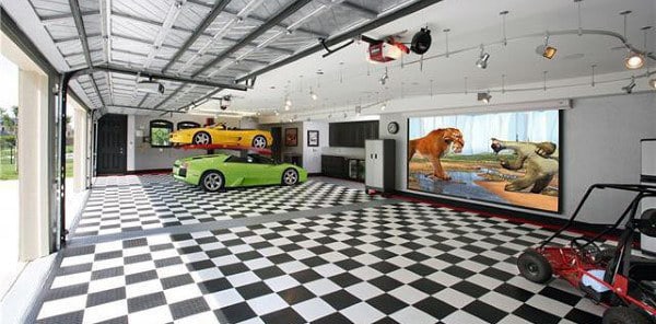 Spacious garage with a checkerboard floor, showcasing sports cars, a large screen of animals, and a compact vehicle