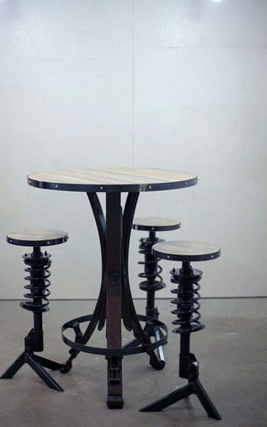 Industrial-style table and three stools with metal bases resembling springs