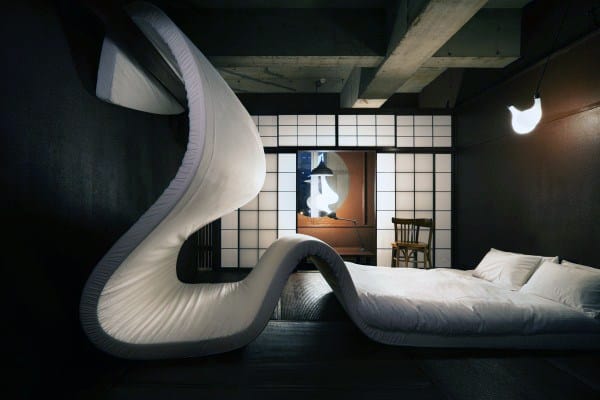Japanese-inspired bedroom with a unique curved bed and traditional shoji screen backdrop.