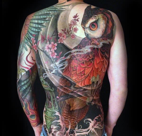 Back tattoo featuring a vibrant owl with feathers, flowers, and intricate designs