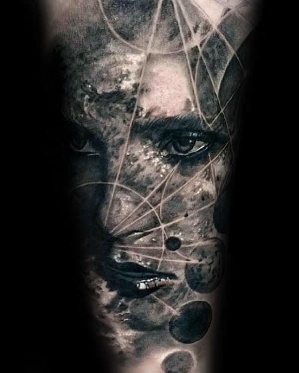 A surreal tattoo featuring an abstract face intertwined with cosmic elements