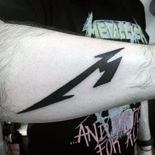Bold black Metallica logo tattoo on forearm, featuring the iconic stylized M design with sharp, angular edges.