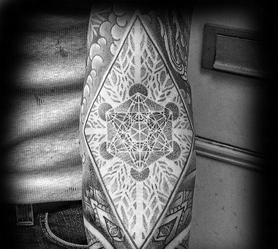 Black and grey Metatron’s Cube tattoo on a forearm, featuring geometric patterns and intricate dotwork inside a diamond frame.