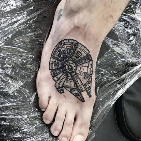 Millennium Falcon tattoo in black ink with subtle shading, placed on the forearm and sized slightly larger than a coin.