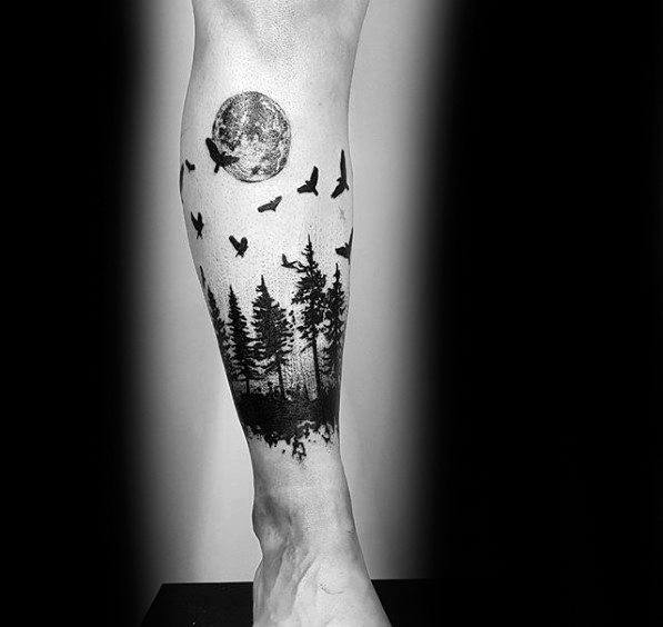 Black forest leg tattoo featuring tall pine trees, a detailed full moon, and birds in flight, creating a mysterious and nature-inspired design.