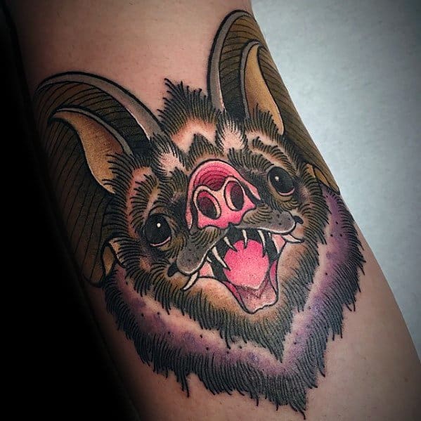 Neo-traditional bat tattoo with large ears, open mouth, and vivid pink nose, detailed in warm brown and black fur tones.