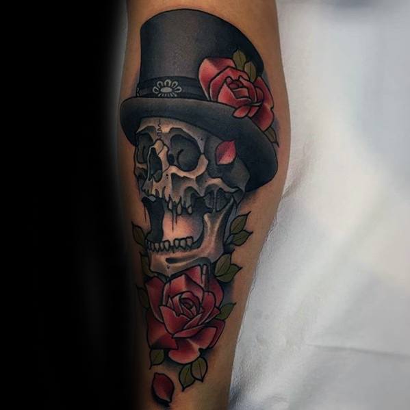 Forearm tattoo of a skull wearing a top hat, adorned with red roses
