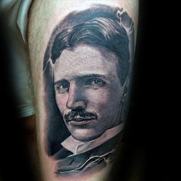 Realistic black and grey portrait tattoo of Nikola Tesla with detailed shading and soft lighting around the edges.