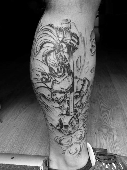 Black and grey linework tattoo of Reinhardt from Overwatch, showcasing his armor and hammer on the back of a man's calf.