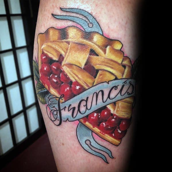 Realistic cherry pie tattoo with a lattice crust, crossed silverware, and a banner reading Francis, blending tradition with a personal touch
