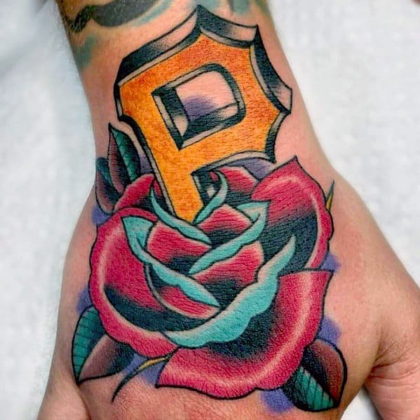 Colorful Pittsburgh Pirates "P" tattoo in gold and black, set above a vibrant red and teal rose on the top of the hand.