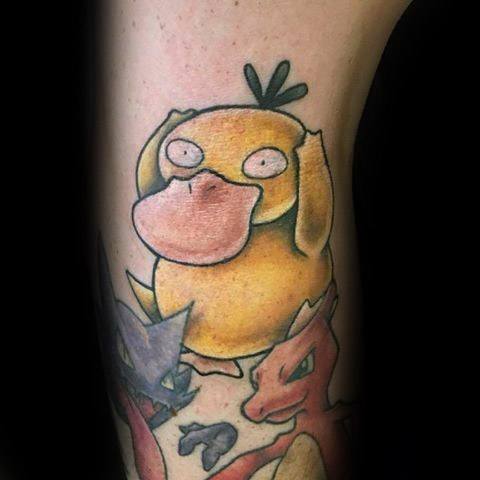Vibrant Psyduck tattoo with a confused expression, surrounded by other Pokémon characters on a man’s upper arm.