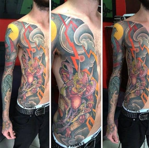 Vivid Japanese side-body tattoo featuring Raijin, the thunder god, with dynamic lightning bolts, clouds, and bold colors