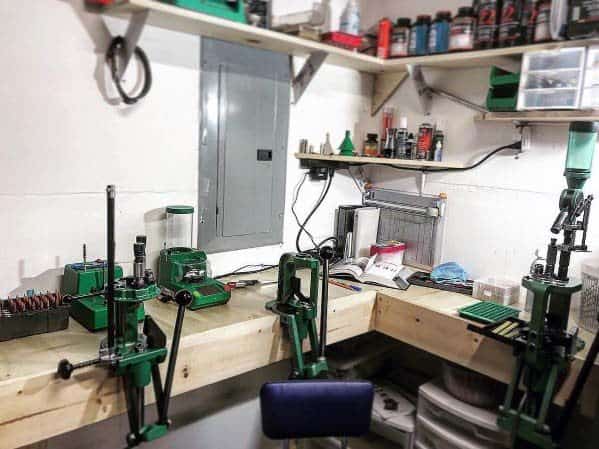 Organized reloading bench with tools, presses, and supplies neatly arranged on sturdy wooden shelves and counters