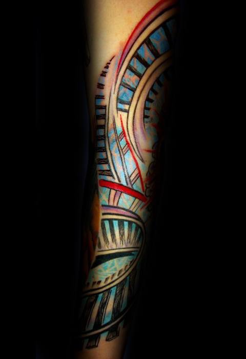 Colorful roller coaster tattoo on forearm featuring dynamic curves, track loops, and vibrant blue and red accents.